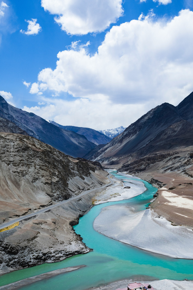 Winding mountain road through barren Ladakh landscape with blue sky