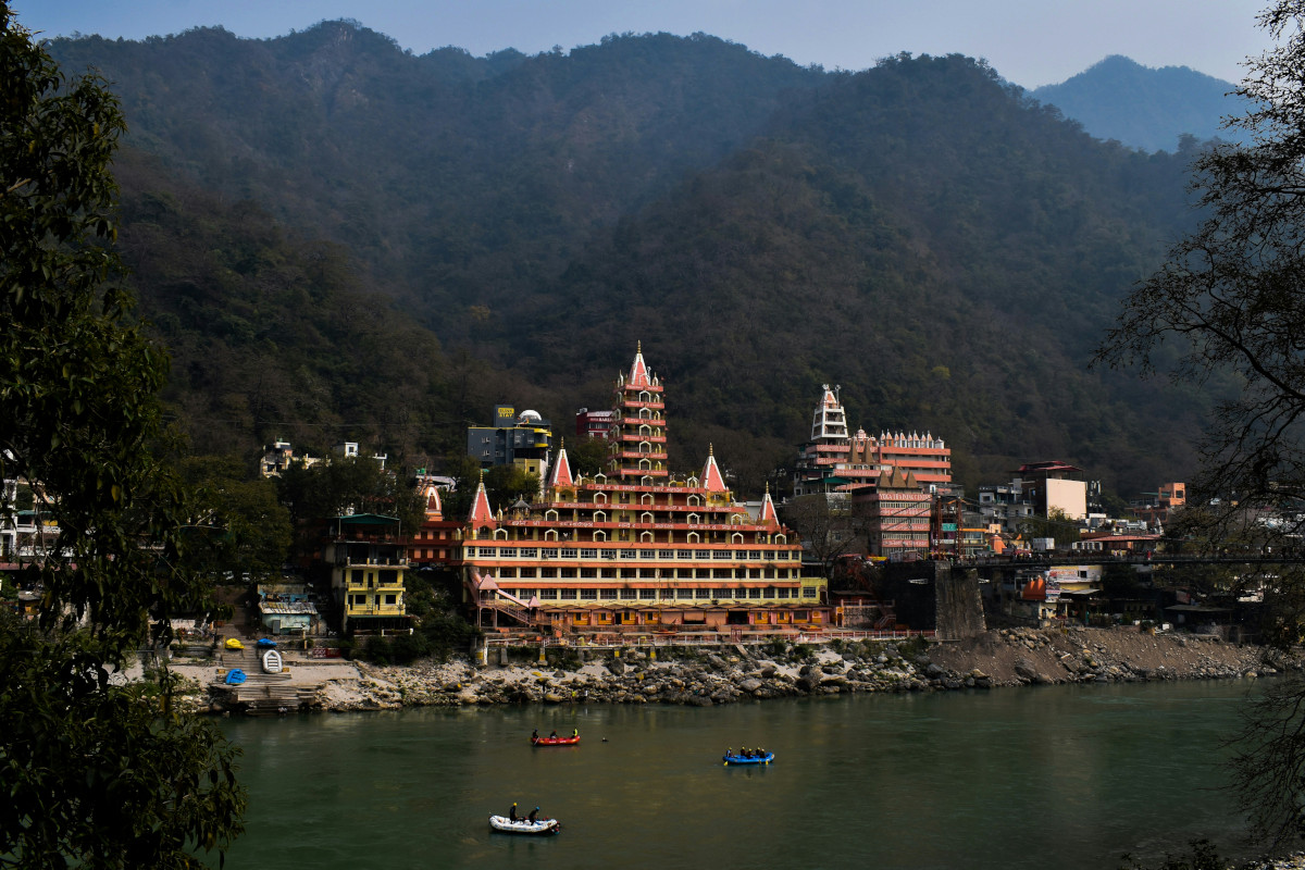 Ganges river flowing through Rishikesh with suspension bridge
