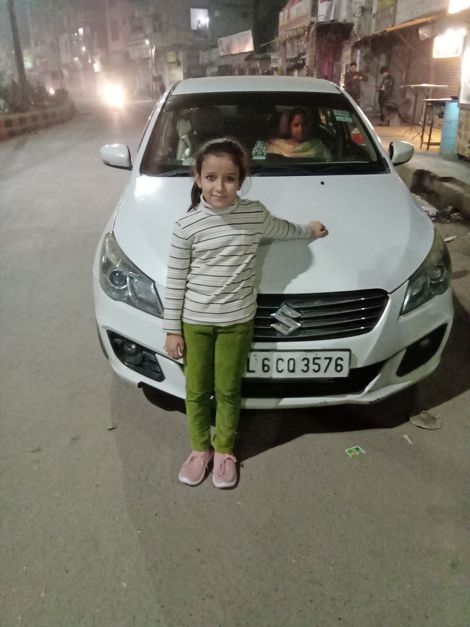 Car driving on an Indian road lined with trees